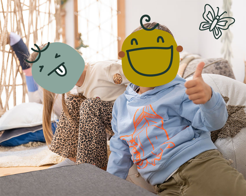 Mädchen und Junge stylisch gekleidet sitzen glücklich nebeneinander auf einem Sitzsack