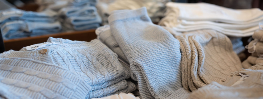 Kleidung liegt in Stapeln im Laden von Bambolino in Fulda