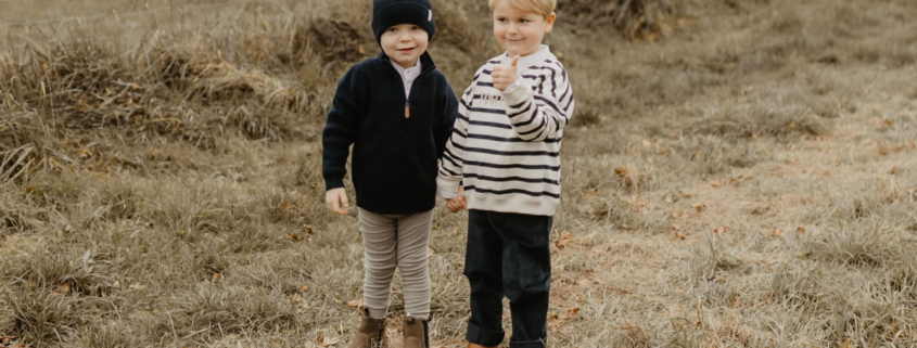 Zwei Jungs stehen in Leevje Herbst-Kleidung auf einem Feld